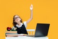Caucasian schoolgirl raises hand up. Pupil sits at laptop during online lesson. Distant School Learning. Royalty Free Stock Photo