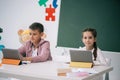 Caucasian schoolkids using digital tablets while studying together in class Royalty Free Stock Photo