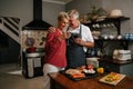 Caucasian senior couple drinking wine in kitchen cooking dinner Royalty Free Stock Photo