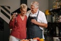 caucasian senior couple drinking wine in kitchen Royalty Free Stock Photo