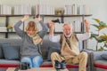 Senior couple playing video game together in living room Royalty Free Stock Photo