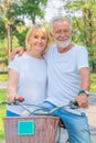 Senior couple happy together riding bicycle outdoor in park in summer Royalty Free Stock Photo