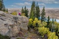 A caucasian senior couple looking out over fall colours from the Conglomerate Cliffs in Cypress Hills, SK