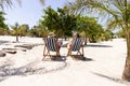 Caucasian senior couple sitting on deck chairs at beach during sunny day Royalty Free Stock Photo