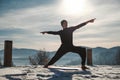 Caucasian senior man doing yoga exercises in front of amazing sunset on the winter mountains. Copy, empty space for text