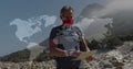 Caucasian senior man in face mask hiking reading map, over moving world map