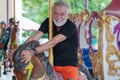 Caucasian Senior man smile on carousel at the amusement park Royalty Free Stock Photo