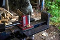 Hydraulic log splitter foreground with workman and woodpile Royalty Free Stock Photo