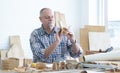 Caucasian senior old white bearded man carpenter working in workshop, use sandpaper polishing handmade wood cup, tools machine and Royalty Free Stock Photo