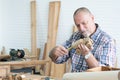 Caucasian senior old white bearded man carpenter working in workshop, use tape measure to measure size a handmade wood car toy, Royalty Free Stock Photo