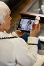 Caucasian senior woman having video call with doctor in sunny living room Royalty Free Stock Photo