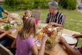 Caucasian senior woman talking with family eating meal together in garden Royalty Free Stock Photo