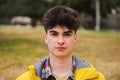 Caucasian serious guy standing in university campus. Portrait of teenage male student looking at camera in a college Royalty Free Stock Photo