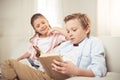 Caucasian sister and brother reading book together at home Royalty Free Stock Photo