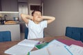 Caucasian small lazy schoolboy closing ears with hands at homework and textbooks. Royalty Free Stock Photo