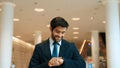 Caucasian smart business man looking at watch while waiting colleague. Exultant. Royalty Free Stock Photo