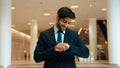 Caucasian smart business man looking at watch while waiting colleague. Exultant. Royalty Free Stock Photo