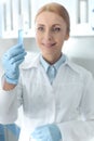 Caucasian smiling chemist in uniform working in lab and looking at tube with reagent Royalty Free Stock Photo