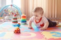 Caucasian smiling child boy with blue eyes lying on floor in kids children room Royalty Free Stock Photo