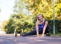 Caucasian smiling grownup woman doing exercise outdoor in fall in urban park, selective focus Royalty Free Stock Photo
