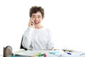 Caucasian smooth-skinned boy talking on cell phone on homeworks Royalty Free Stock Photo