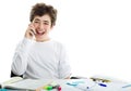 Caucasian smooth-skinned boy talking on cell phone on homeworks Royalty Free Stock Photo