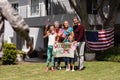 Caucasian soldier father and family meeting outside home with welcome sign and american flags Royalty Free Stock Photo