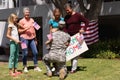 Caucasian soldier father greeting family with welcome sign and american flags outside home Royalty Free Stock Photo