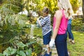 Caucasian son and daughter watering plants in garden with mother and father in background Royalty Free Stock Photo