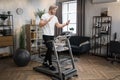 Caucasian sportsman having online video class training on smartphone using treadmill Royalty Free Stock Photo