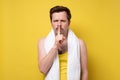 Caucasian sporty man with towel making silence gesture. Royalty Free Stock Photo