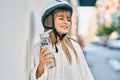 Caucasian sporty teenager girl wearing bike helmet and drinking bottle of water at the city Royalty Free Stock Photo