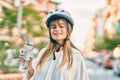 Caucasian sporty teenager girl wearing bike helmet and drinking bottle of water at the city Royalty Free Stock Photo