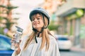 Caucasian sporty teenager girl wearing bike helmet and drinking bottle of water at the city Royalty Free Stock Photo