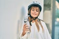 Caucasian sporty teenager girl wearing bike helmet and drinking bottle of water at the city Royalty Free Stock Photo