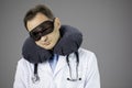 Caucasian surgeon doctor with travel pillow over neck and sleep mask in the eyes Royalty Free Stock Photo