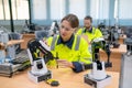 Caucasian technician or engineer worker woman maintenance and check the system of small robotic machine on table in factory Royalty Free Stock Photo