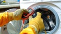 Caucasian technician using multimeter to test washing machine functionality in workshop. concept of appliance repair