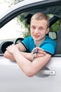 Caucasian teen boy showing new car key and car. Royalty Free Stock Photo