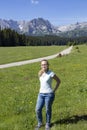 Caucasian teenage girl with glasses on a green meadow at the foot of the mountain, Montenegro