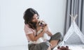 Caucasian teenage girl playing with shih tzu puppy dog at home. Young beautiful woman sitting on floor, having fun hugging little Royalty Free Stock Photo