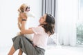 Caucasian teenage girl playing with shih tzu puppy dog at home. Young beautiful woman sitting on floor, smiling, having fun Royalty Free Stock Photo