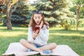 Caucasian teenage girl talking over cell mobile phone outside in park Caucasian teenage girl making selfie photo with her phone Royalty Free Stock Photo