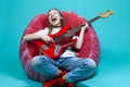 Caucasian Teenager Guitar Player With Red Shiny Bass Guitar Posing In Casual White Shirt With Smiling Facial Expression While