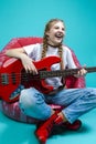 Expressive Caucasian Teenager Guitar Player With Red Shiny Bass Guitar Posing In Casual White Shirt With Smiling Facial Expression