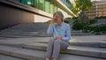 Caucasian tired business woman mature old senior sick unwell businesswoman on city stairs rest overwork hard day Royalty Free Stock Photo