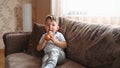 Caucasian toddler boy with ice cream watching tv on the couch in the living room. Bad habits of children Royalty Free Stock Photo