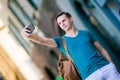 Caucasian tourist with smartphone in hands walking along the deserted italian streets in Rome. Young urban boy on Royalty Free Stock Photo