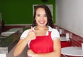 Caucasian waitress in a fast food restaurant showing thumb Royalty Free Stock Photo