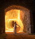 Caucasian white female model with long hair, in a white dress standing and throws gleaming sparks.